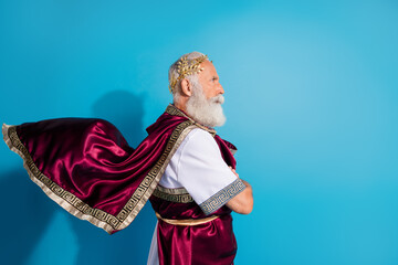 Photo of handsome senior male profile crossed hands confident wear ancient greek god king dress isolated on blue color background