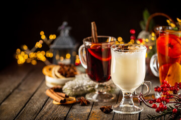 fresh yellow eggnog, grog and fruity red mulled wine with Christmas decoration. Selection of autumn or winter alcoholic hot drinks