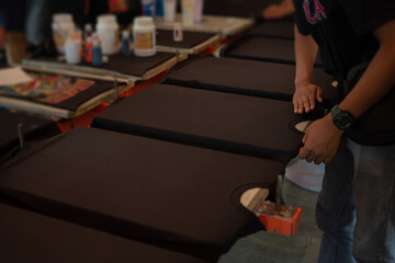 Fototapeta premium Black shirts laying flat on a printing table