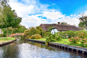 Fototapeta premium Traditional Dutch thatched-roof cottages on the canal in the village of Giethoorn, Netherlands