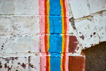 Vibrant Vertical Stripes on Textured Brick Wall Eye-Level View