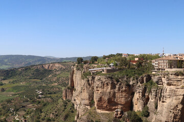 Ronda, spain, perched on cliff overlooking serene countryside with blue sky