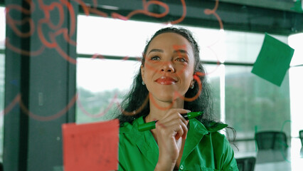 Young hispanic employee writing on colorful sticky notes. Smart businesswoman sharing marketing...