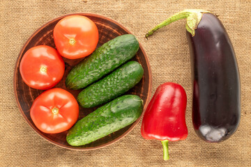 Fresh ripe vegetables on jute cloth, macro, top view.