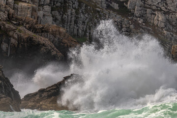 Large waves of the Atlantic Ocean crash against the rocks of a cliff