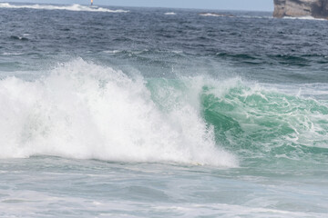 Wave of the green and blue Atlantic Ocean at the edge of a beach in the Iroise Sea.