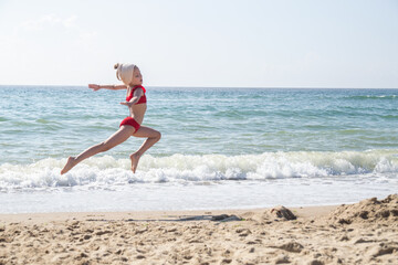 Fototapeta premium a young rhythmic gymnast trains on the seashore