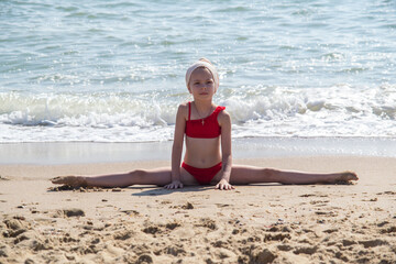 a young rhythmic gymnast trains on the seashore