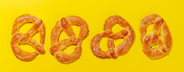 Pretzels scattered across a bright yellow background