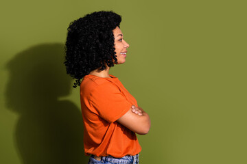 Profile portrait of nice young woman crossed arms empty space wear orange t-shirt isolated on khaki color background