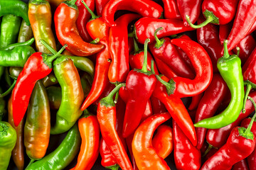 Top view of mixed chili pepper texture as background. Chili pepper pattern. Red, orange and green chili pepper.