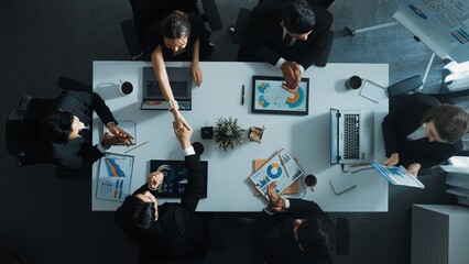Top view of smart executive manager holding stock market investment chart while planning marketing strategy with diverse group. Smart business team brainstorming and working together. Directorate.