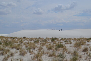 People are walking into a dunes in the White Sands National Park, New Mexico