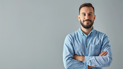 Obraz premium Modern business man in casual blue shirt standing with crossed arms, isolated on grey background