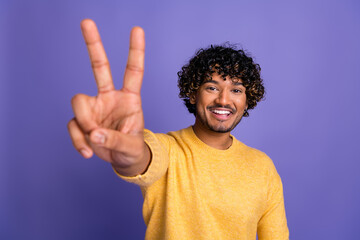 Photo of positive funny man wear trendy yellow clothes v-sign gesture isolated on violet color background