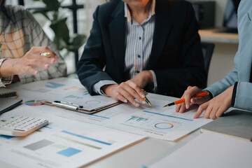 Collaborative business team analyzing financial data with charts and graphs, strategizing for...