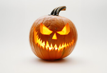 Fototapeta premium Scary Carved Pumpkin Illuminated from Inside with an Intense Halloween Expression