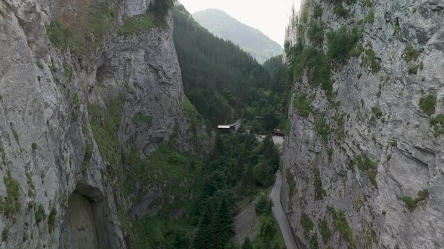 Camera panning over narrow valley with road and buildings