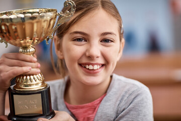 Girl portrait, child and trophy for education at school, learning achievement and math champion. Female person, kid and golden cup for knowledge development, academic growth and win student award