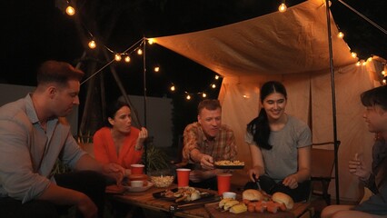 Family gather for holiday celebration in garden. Family member gather have dinner. Outdoor camping...