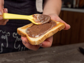 chocolate paste, hand holding a piece of cake, 
