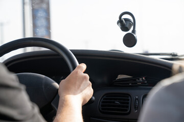 A person is driving a car with a steering wheel in their hand