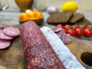 Wooden cutting board with sliced salami. High quality photo