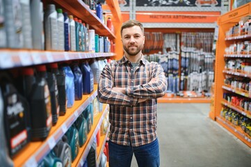 seller man with canister of motor oil in auto store