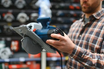 A man in a hardware store chooses a new orbital sander