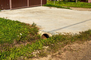 Car entrance through a drainage ditch. Concreted entrance to the site