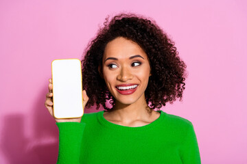 Photo of attractive young woman hold device look white screen empty space dressed stylish green clothes isolated on pink color background