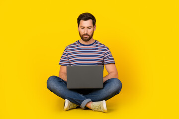 Photo of young modern guy with laptop it specialist javascript developer sitting write a code isolated on yellow color background