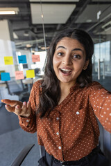 Office worker smiling and looking at phone camera, businesswoman using smartphone for video call,...