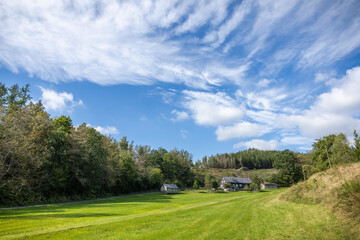 Einsames Haus im Wald mit großer Wiese davor