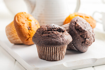 Sweet muffin cakes on cutting board on white table.