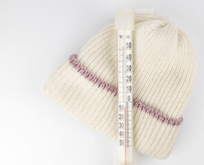 A thermometer showing the sub-zero temperature outside in celsius on a child's winter hat. The concept of a cold in winter.