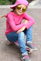 little girl in sunglasses on skateboard