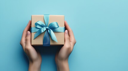 Male hands holding a gift box with a blue ribbon over a blue background. transparent background