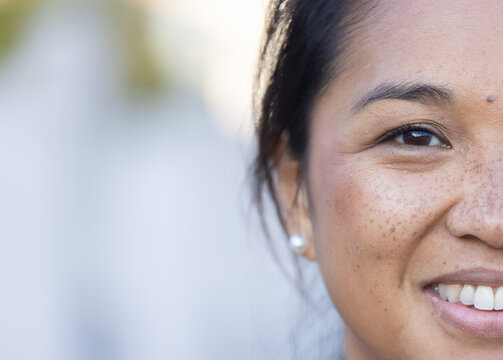Smiling woman with freckles and pearl earring enjoying home lifestyle