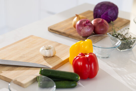 Preparing vegetables, garlic, and herbs on cutting board in modern kitchen