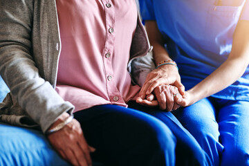 Healthcare, trust and holding hands with nurse and old woman for caregiver, occupational therapy and empathy. Helping others, volunteer and medical support with closeup of people in retirement home