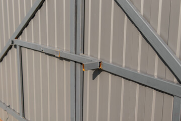 Grey metal profile sheet fence. Car fence gate. The bolt on gate