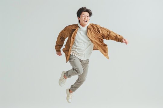 Asian man running and jumping, happy expression, white background