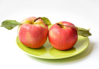 two red apples on a green plate on a white background. tasty and healthy fruits for children and adults. vitamins, iron, minerals, antioxidant. food for snacks and during a diet