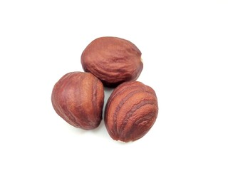 Top view of three raw hazelnuts, isolated on white background. Raw hazelnuts are rich in healthy fats, vitamins E and B, and essential minerals like magnesium.