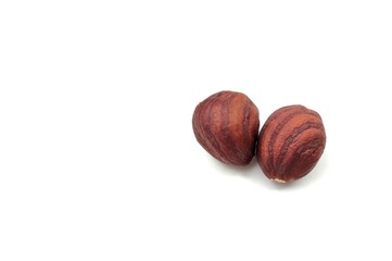 Photo of two raw hazelnuts, isolated on white background with space for text. Raw hazelnuts are rich in healthy fats, vitamins E and B, and essential minerals like magnesium.