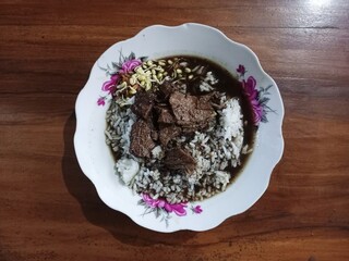 Nasi Rawon is white rice with side dishes of beef spice soup and thick thick sauce plus bean sprout