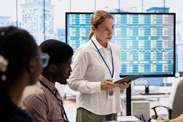 Diverse work team collaborating on project management tasks, utilizing smart technology and detailed analytics to optimize resource allocation and ensure enterprise objectives.