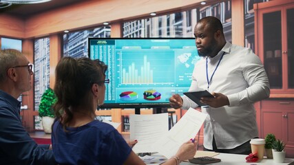 Obraz premium Broker advisor highlighting and pointing out important terms of a contract, middle aged people negotiating with financial expert for a retirement plan and pension option. Camera B.