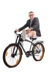 Obraz premium Funny businessman in suit and sportswear riding bicycle on white background